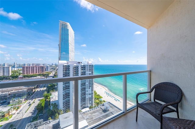 balcony featuring a water view and a beach view