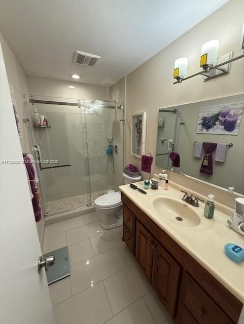 bathroom featuring tile patterned flooring, vanity, a shower with shower door, and toilet