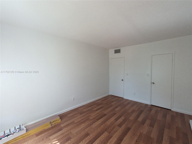 unfurnished bedroom featuring dark hardwood / wood-style floors