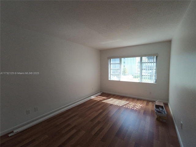 unfurnished room with dark hardwood / wood-style flooring