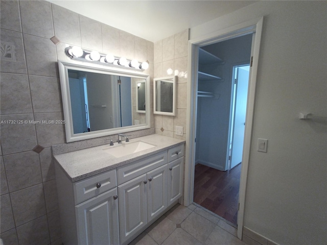 bathroom with tile walls, vanity, and tile patterned floors