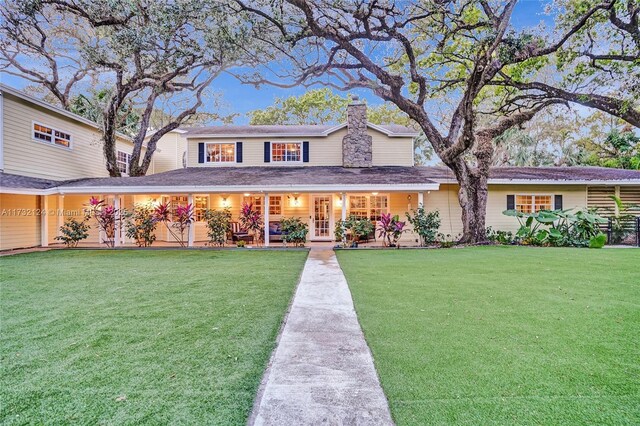 view of front of home with covered porch and a front lawn