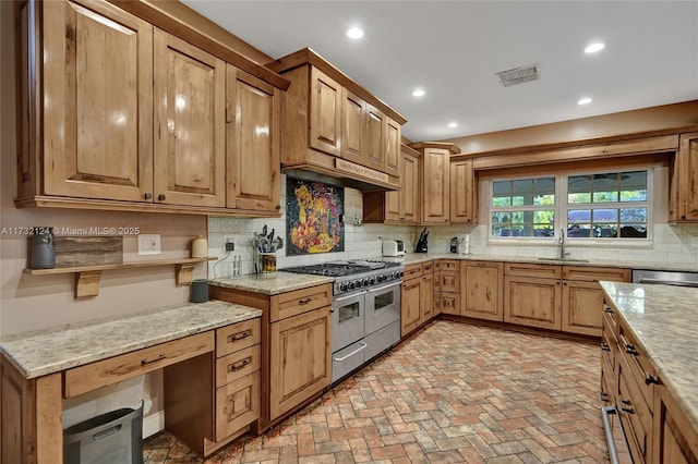 kitchen featuring extractor fan, sink, backsplash, stainless steel appliances, and light stone countertops