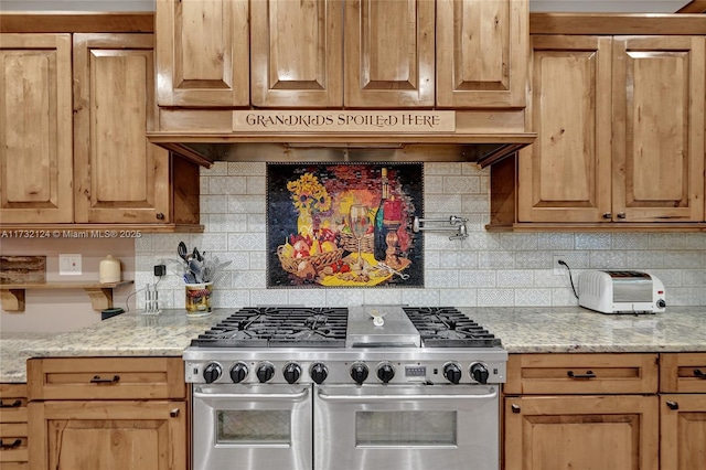 kitchen featuring range with two ovens, custom exhaust hood, backsplash, and light stone counters