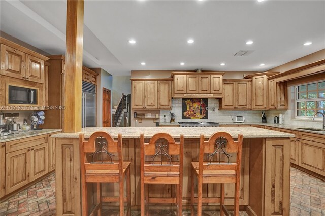 kitchen featuring stainless steel appliances, a center island, and a kitchen bar