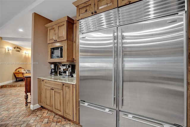 kitchen with built in appliances and light stone countertops