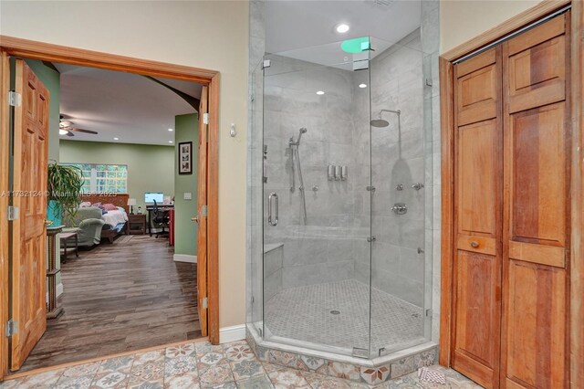 bathroom featuring ceiling fan and a shower with shower door