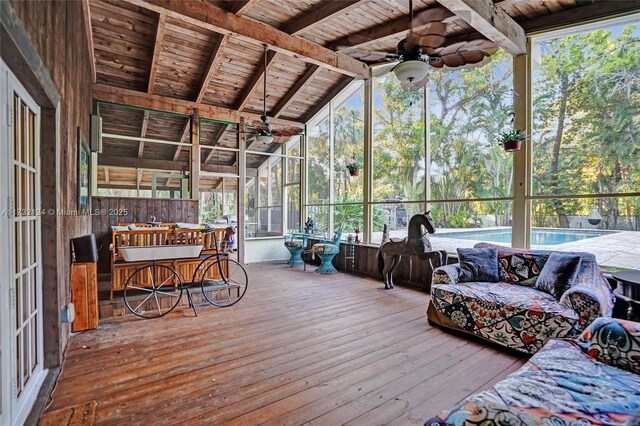 sunroom / solarium featuring lofted ceiling with beams, wood ceiling, and ceiling fan