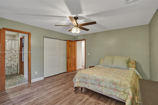 bedroom with a closet, ensuite bath, ceiling fan, and light hardwood / wood-style flooring