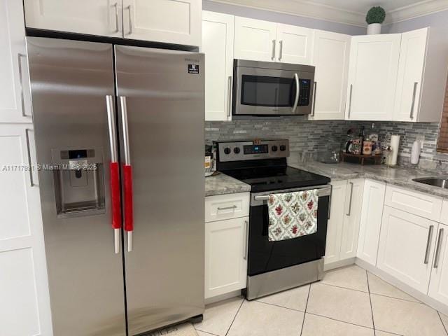 kitchen with light stone countertops, stainless steel appliances, and white cabinets