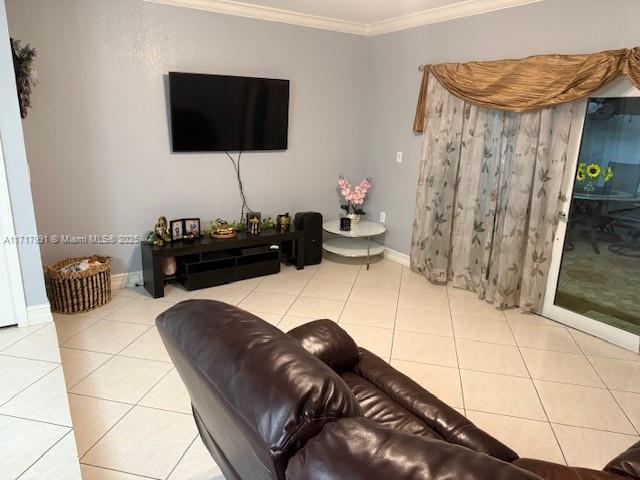 living room featuring ornamental molding and light tile patterned floors