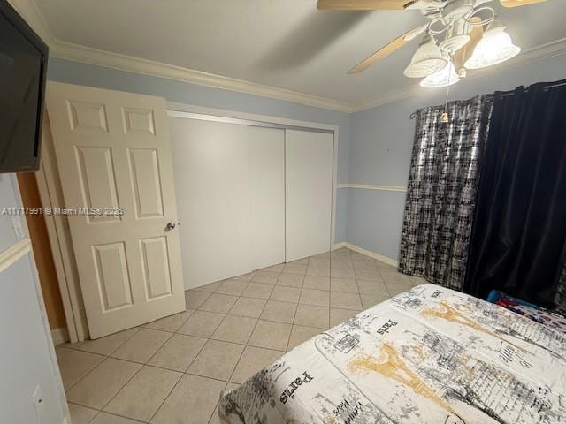 tiled bedroom featuring crown molding, ceiling fan, and a closet