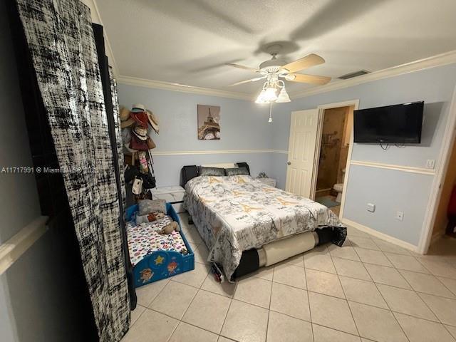 bedroom featuring light tile patterned floors, ornamental molding, and ceiling fan