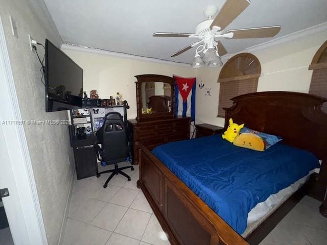 bedroom featuring ceiling fan, ornamental molding, and light tile patterned floors