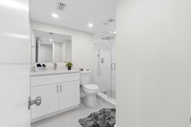 bathroom with vanity, a shower with door, and toilet