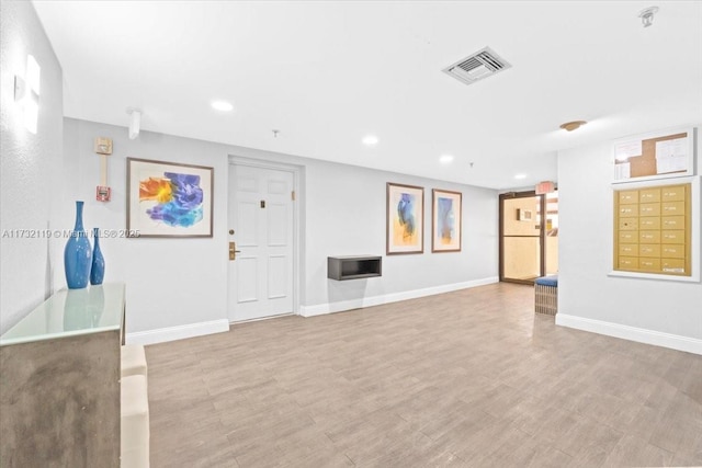 unfurnished living room with light hardwood / wood-style flooring and mail boxes