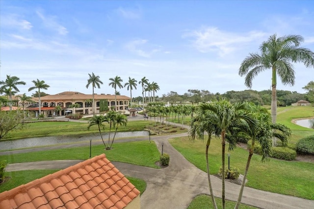 surrounding community with a water view and a yard