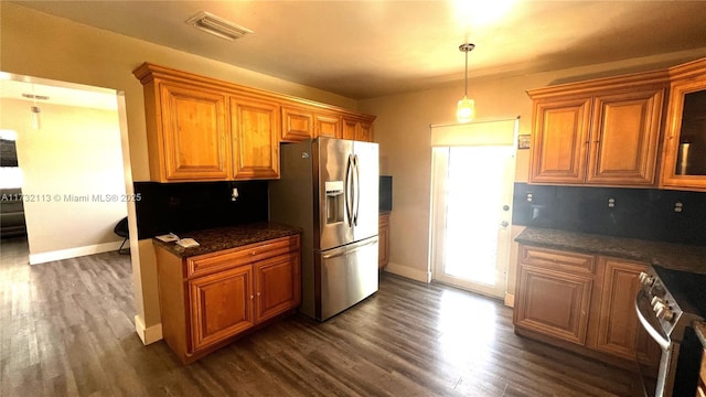 kitchen with dark stone countertops, backsplash, dark hardwood / wood-style flooring, hanging light fixtures, and stainless steel appliances