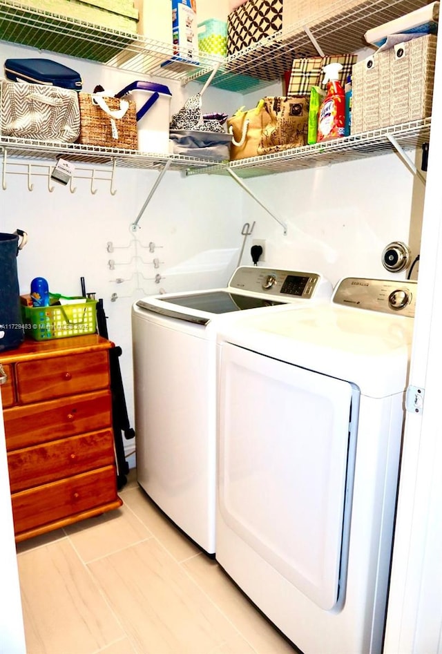 laundry area with separate washer and dryer and light tile patterned floors