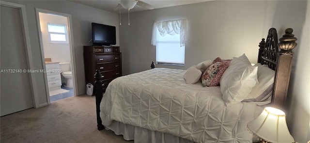 carpeted bedroom featuring ensuite bath and ceiling fan