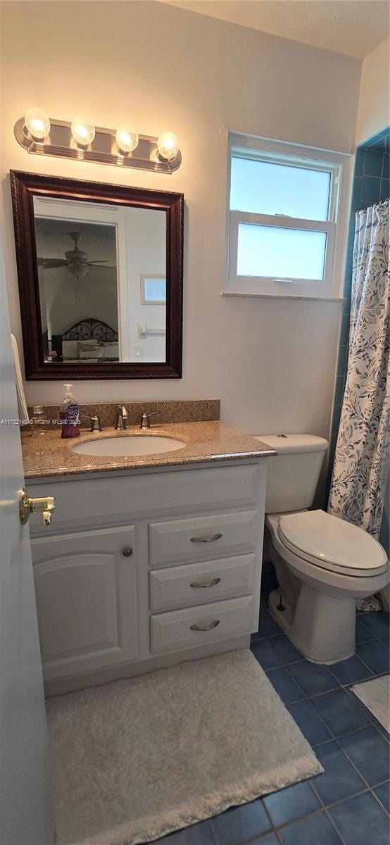 bathroom with vanity, walk in shower, tile patterned floors, and toilet