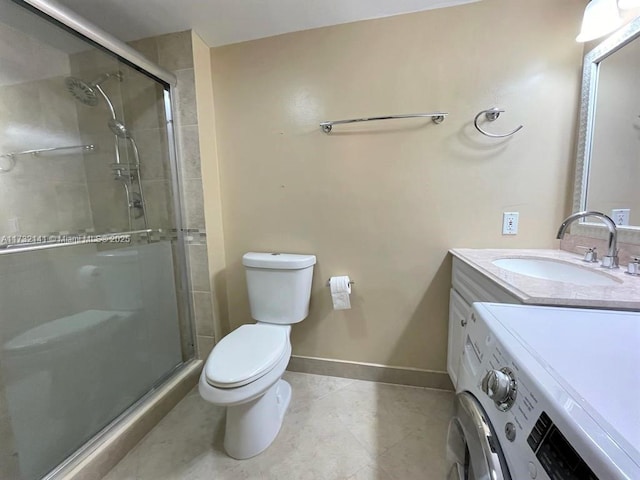 bathroom featuring a shower with door, vanity, washer / dryer, tile patterned floors, and toilet