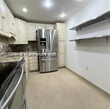 kitchen featuring tasteful backsplash, white cabinetry, and appliances with stainless steel finishes