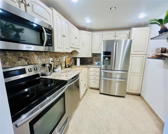 kitchen with sink, light tile patterned floors, white cabinets, and appliances with stainless steel finishes