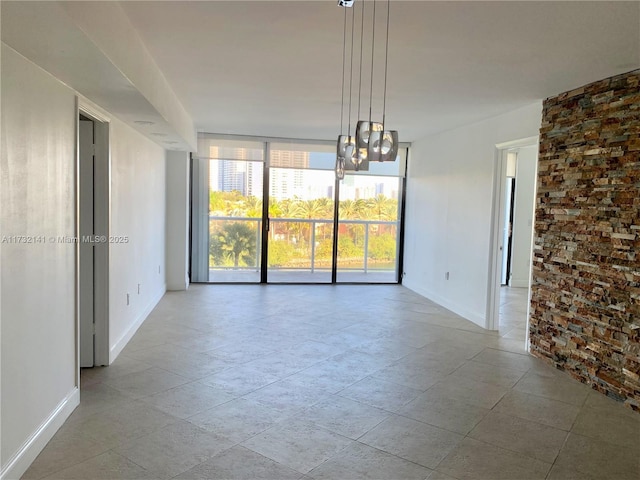 spare room with a wall of windows and a chandelier