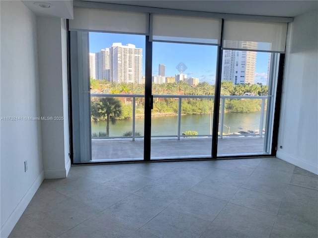 empty room with a water view, a wall of windows, and plenty of natural light