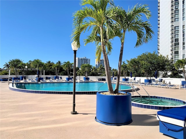 view of pool featuring a community hot tub and a patio