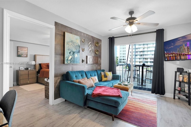 living room with ceiling fan and light wood-type flooring