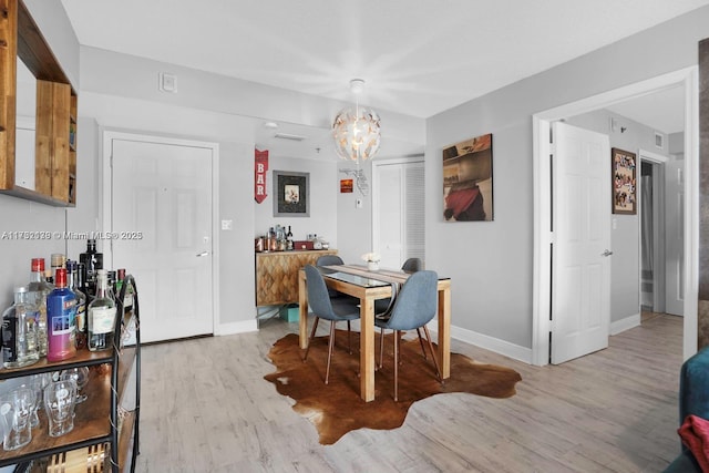 dining space featuring a chandelier and light hardwood / wood-style flooring