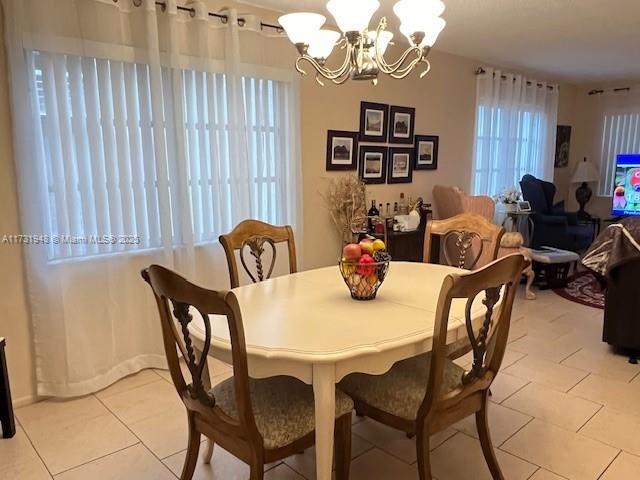 dining room with an inviting chandelier and light tile patterned floors