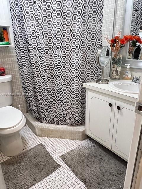 bathroom featuring walk in shower, tile patterned floors, toilet, and vanity