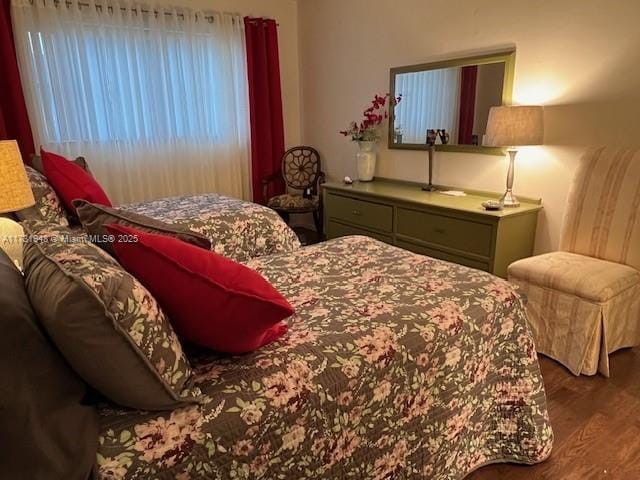 bedroom with dark wood-type flooring