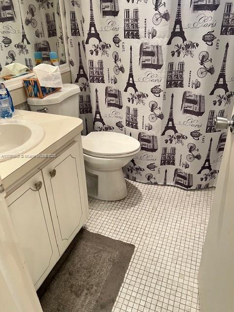 bathroom featuring vanity, tile patterned floors, and toilet