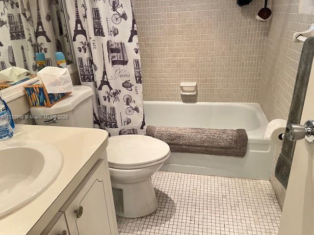 full bathroom with vanity, tile patterned floors, shower / bath combo with shower curtain, and toilet