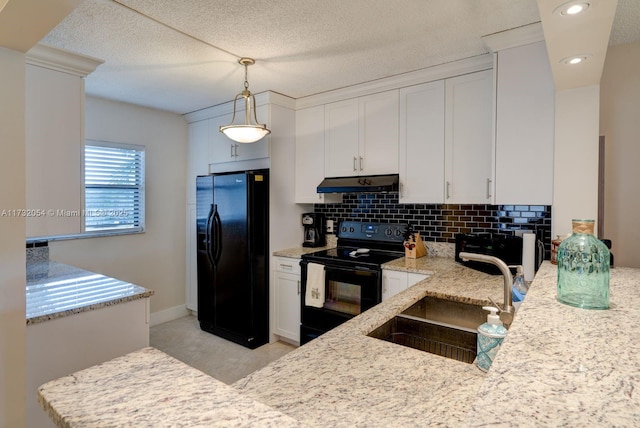 kitchen with tasteful backsplash, white cabinetry, sink, hanging light fixtures, and black appliances