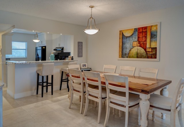 dining room featuring light tile patterned floors and a textured ceiling