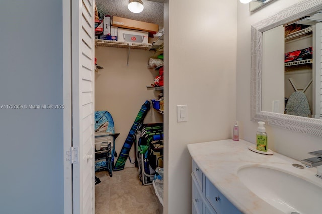 bathroom featuring tile patterned floors, vanity, and a textured ceiling