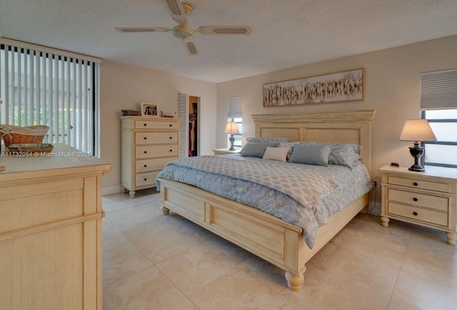 tiled bedroom featuring ceiling fan, access to outside, and a textured ceiling