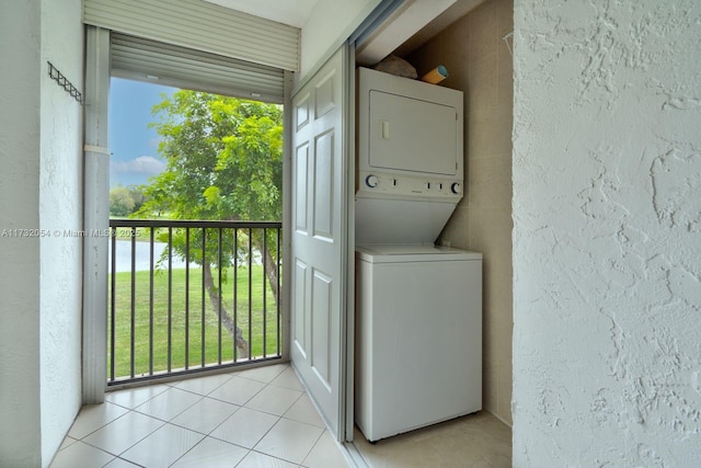 washroom featuring a water view, stacked washing maching and dryer, and light tile patterned floors