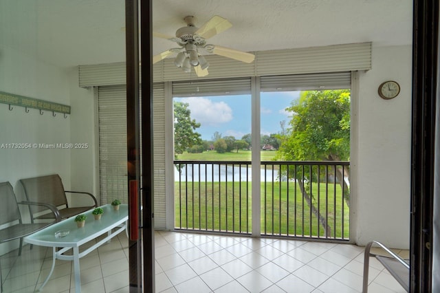 sunroom / solarium with a water view, plenty of natural light, and ceiling fan