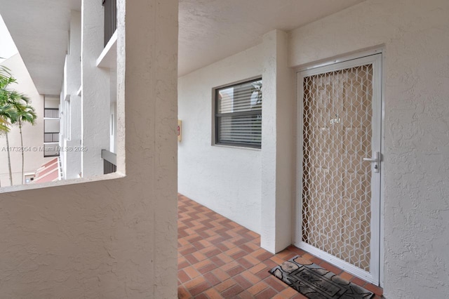 view of exterior entry with a balcony