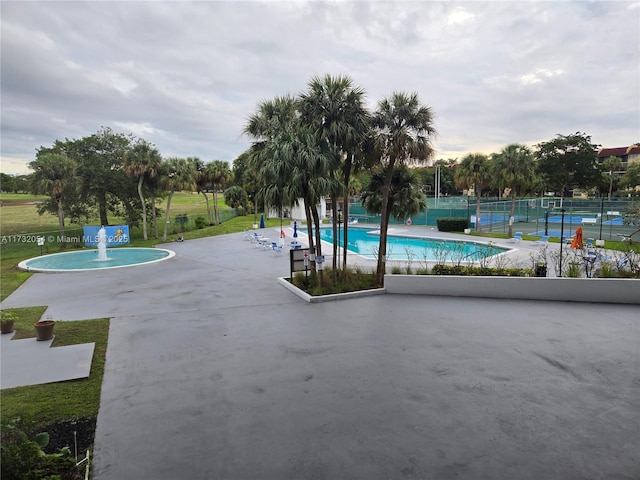 view of swimming pool with tennis court