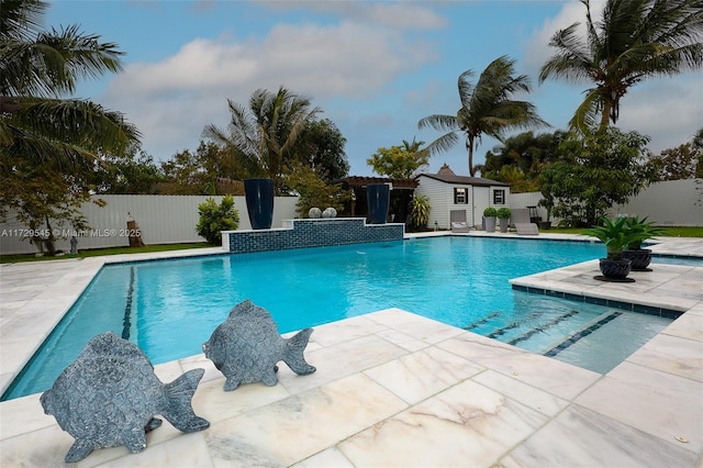 view of swimming pool with a fenced in pool, an outbuilding, a patio area, and a fenced backyard