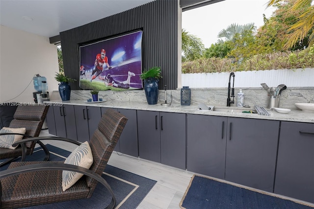 view of patio / terrace featuring a sink, outdoor dry bar, and fence