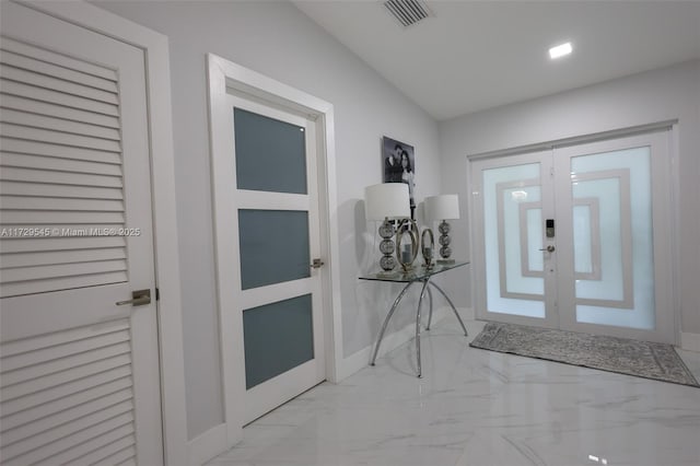 foyer featuring french doors, visible vents, marble finish floor, and baseboards