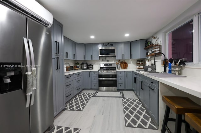 kitchen featuring stainless steel appliances, open shelves, gray cabinets, and light countertops